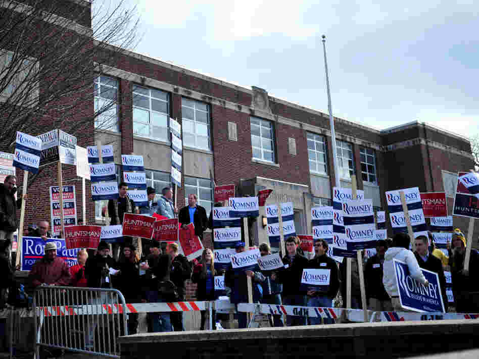Supporters for various candidates hold signs at the Webster School polling location in Manchester, N.H., on Tuesday. 