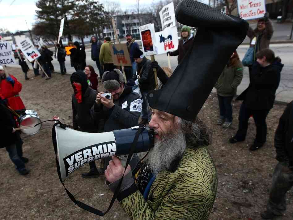 Fringe candidate Vermin Supreme demonstrates with Occupy protesters on Sunday, outside a restaurant where Republican presidential candidate Newt Gingrich held a town hall meeting in New Hampshire.