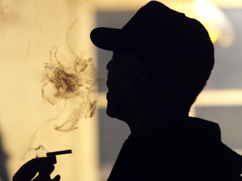 An unidentified man smokes medical marijuana during a karaoke night at the Cannabis Cafe in Portland, Ore., last May.