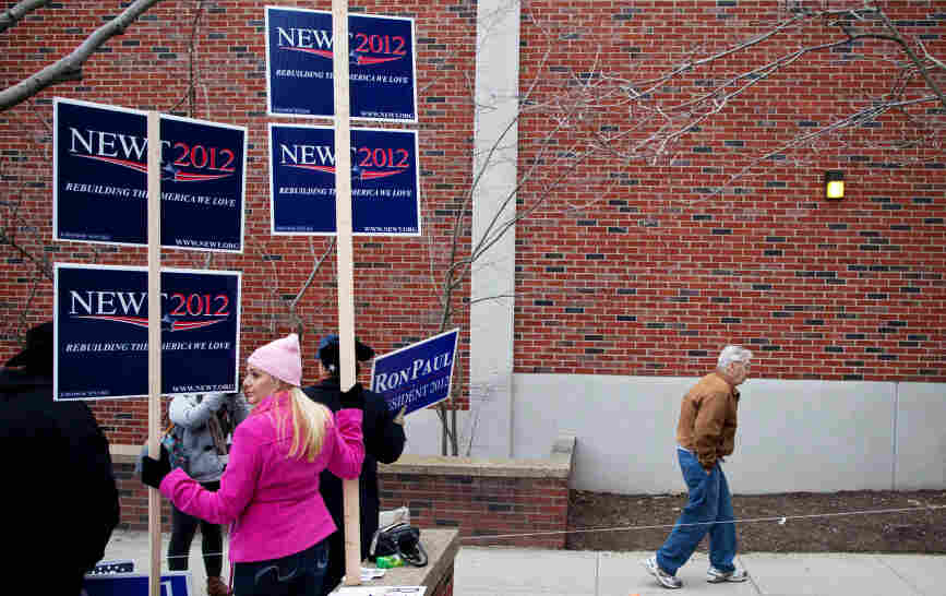 A man walks past campaign workers touting their candidates during voting in the New Hampshire primary, at Webster Elementary School in Manchester on Tuesday. A man walks past campaign workers touting their candidates during voting in the New Hampshire primary, at Webster Elementary School in Manchester on Tuesday.