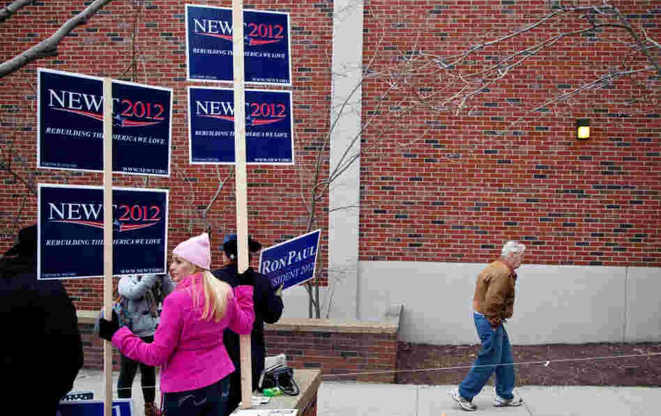 A man walks past campaign workers touting their candidates during voting in the New Hampshire primary, at Webster Elementary School in Manchester on Tuesday. A man walks past campaign workers touting their candidates during voting in the New Hampshire primary, at Webster Elementary School in Manchester on Tuesday.