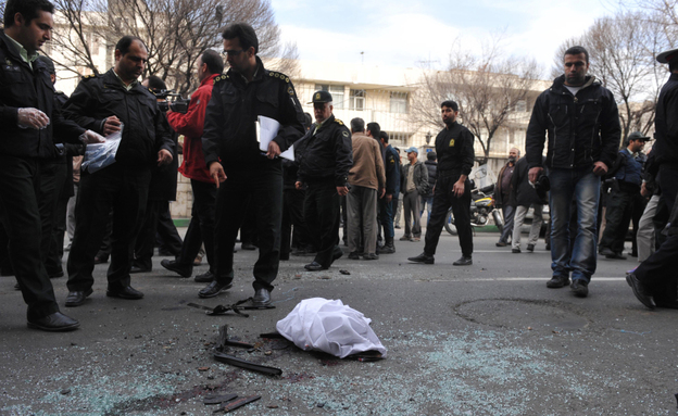 Iranian security forces inspect the site where a magnetic bomb attached to a car by a motorcyclist exploded outside a university in Tehran on Wednesday, killing nuclear scientist Mostafa Ahmadi Roshan.