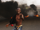 The Nigerian government removed fuel subsidies, which drove up prices and prompted nationwide strikes this week. Here, a young man protests in front of burning tires in the commercial capital Lagos on Tuesday. The Nigerian government removed fuel subsidies, which drove up prices and prompted nationwide strikes this week. Here, a young man protests in front of burning tires in the commercial capital Lagos on Tuesday.