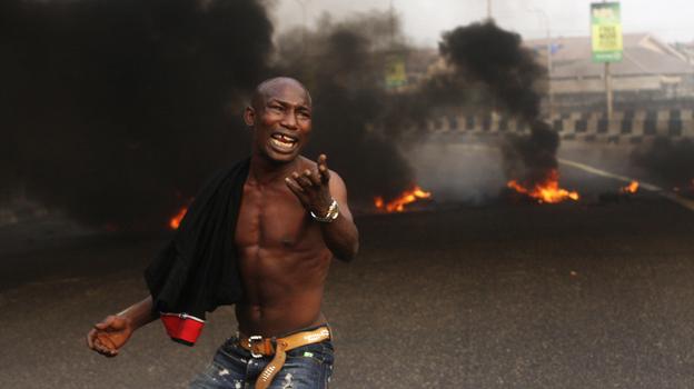 The Nigerian government removed fuel subsidies, which drove up prices and prompted nationwide strikes this week. Here, a young man protests in front of burning tires in the commercial capital Lagos on Tuesday. 
