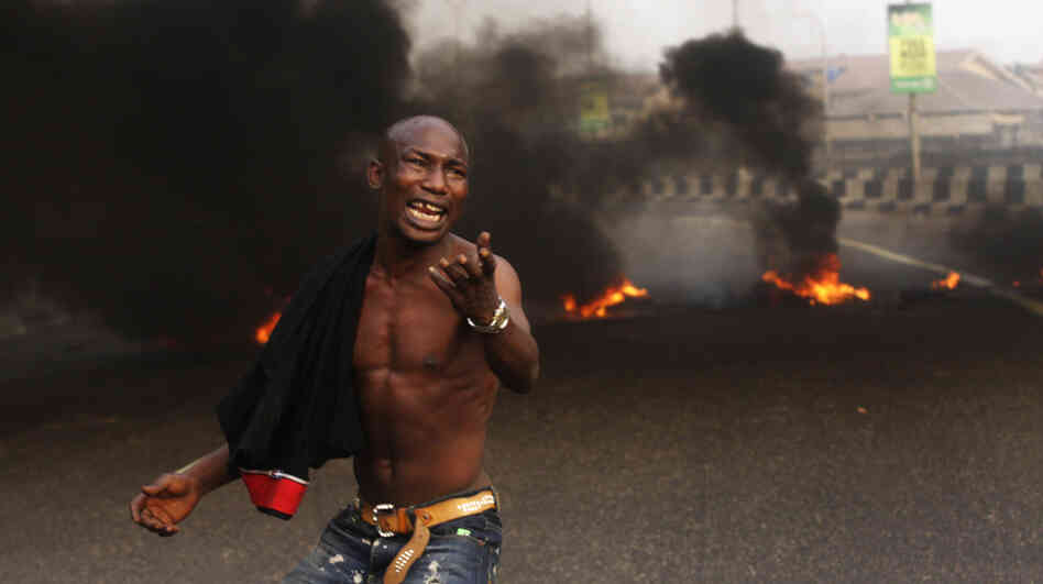 The Nigerian government removed fuel subsidies, which drove up prices and prompted nationwide strikes this week. Here, a young man protests in front of burning tires in the commercial capital Lagos on Tuesday. 