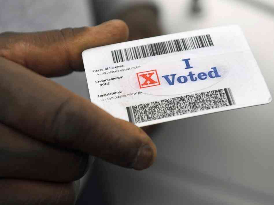 Verdell Winder of Washington holds up his driver's license showing his "I Voted" sticker after voting on Election Day on Nov. 4, 2008.