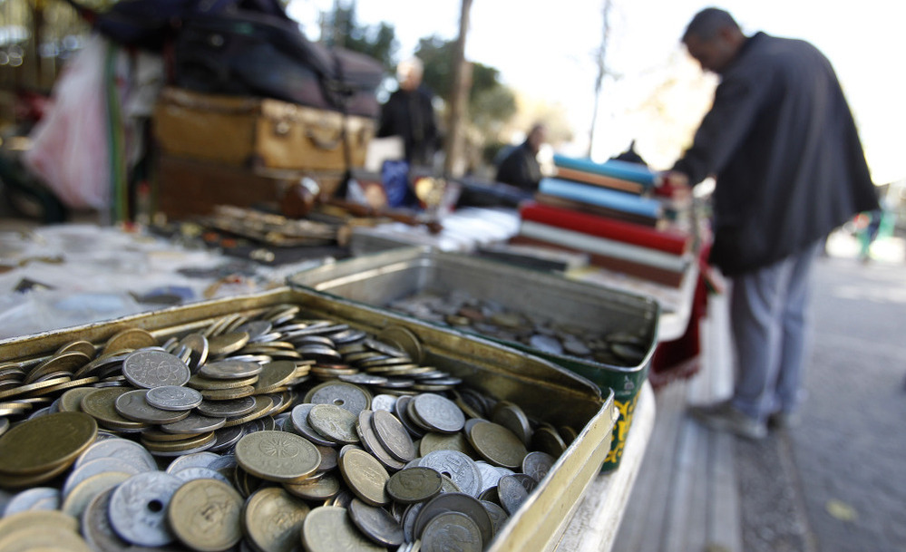 Old drachma coins are displayed for sale at an outdoor market in Athens. If the international community concludes that Greece can't be saved as a member of the Eurozone it will have to revert to its old currency.