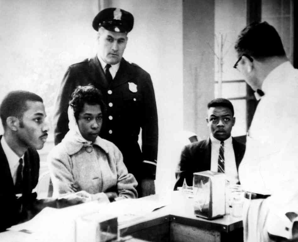 Victor Cobb (right), the manager of a dining room in Atlanta's Trailways Bus Terminal, asks African-American demonstrators to leave his lunch counter on March 16, 1960. The demonstrators stared at him in silence and refused to leave; they were then arrested. 