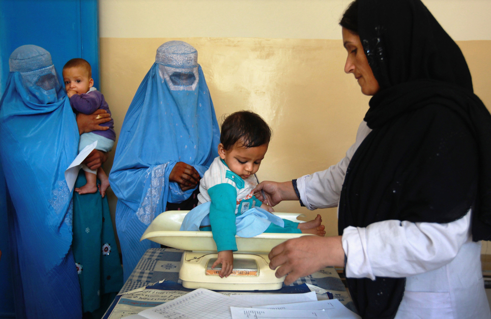 A nurse weighs an Afghan child at a U.S.-funded clinic in Farza, Afghanistan, in September. A new U.S.-sponsored survey shows dramatic gains in life expectancy and other aspects of health care in Afghanistan. But some experts are questioning the accuracy of the results.