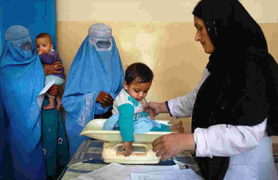 A nurse weighs an Afghan child at a U.S.-funded clinic in Farza, Afghanistan, in September. A new U.S.-sponsored survey shows dramatic gains in life expectancy and other aspects of health care in Afghanistan. But some experts are questioning the accuracy of the results.