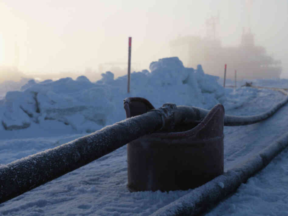 In this photo provided by the U.S. Coast Guard, two hose lines can been seen running  from the Russian tanker Renda to land in Nome, Alaska. 
