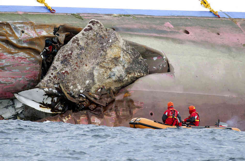 A large rock emerges from the side of the luxury liner a day after the ship ran aground. Crews are working to remove fuel from the ship in an effort to preserve a stretch of Mediterranean described as the biggest designated marine park in Europe. 