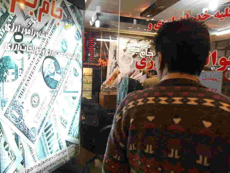 A man looks at the rates outside a currency exchange in a shopping center in Tehran. A man looks at the rates outside a currency exchange in a shopping center in Tehran.