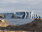 The cruise ship Costa Concordia leans on its side off the Tuscan island of Giglio, Italy. The cruise ship Costa Concordia leans on its side off the Tuscan island of Giglio, Italy.