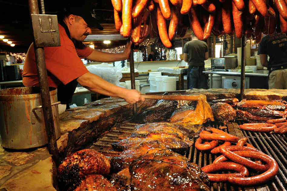 Angel Gonzales mops the meats with sauce at The Salt Lick in Driftwood, Texas.