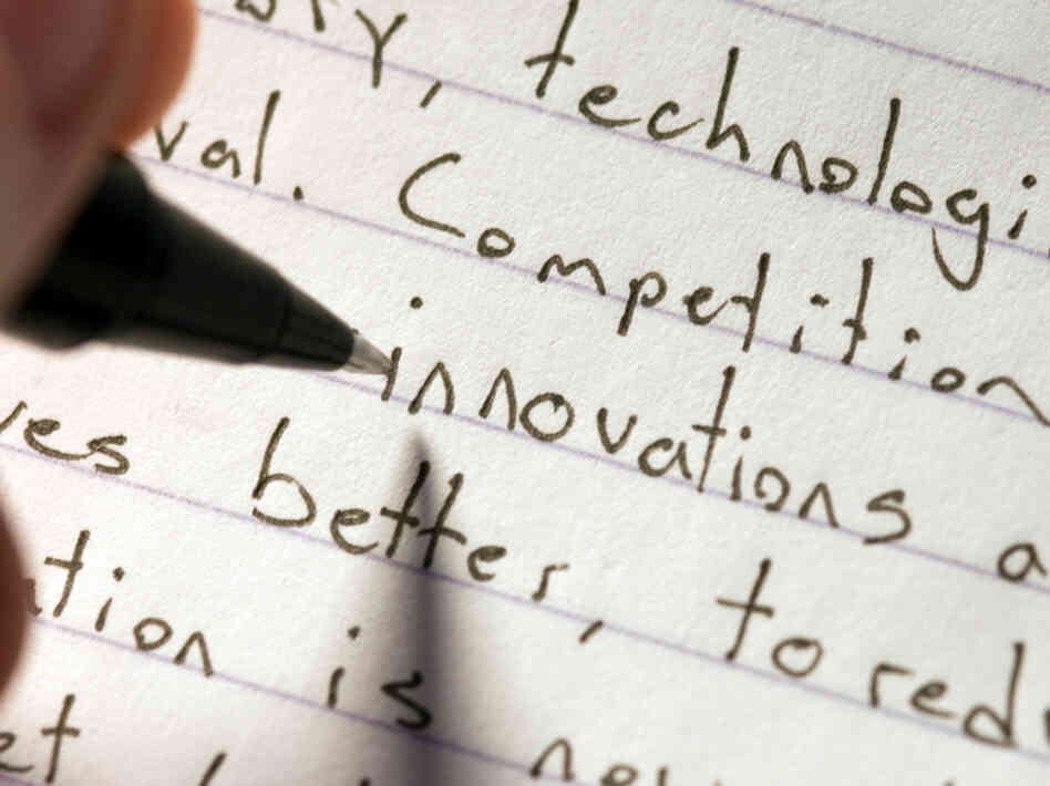 A person writes an essay by hand. A person writes an essay by hand.