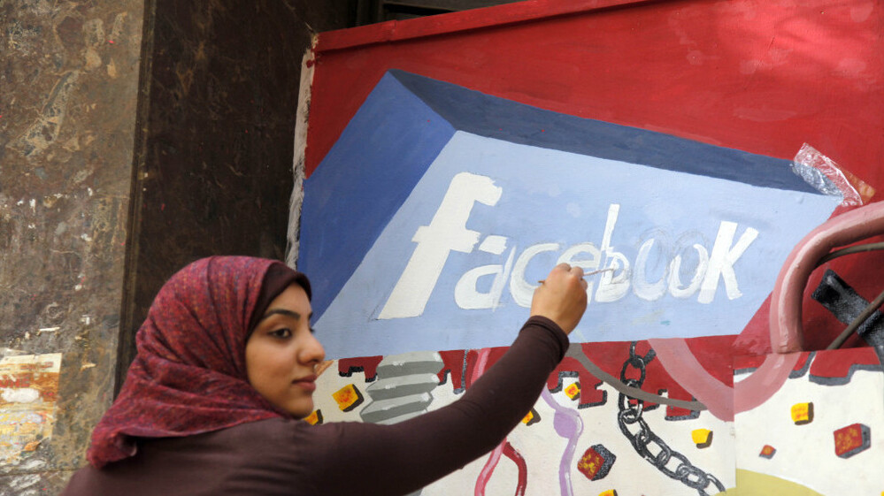 A student paints the Facebook logo on a mural commemorating Egypt's revolution last spring. The team from the CIA's Open Source Center monitors social media activity overseas.