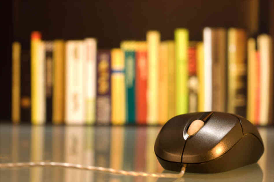 A computer mouse in front of a shelf of books. A computer mouse in front of a shelf of books.