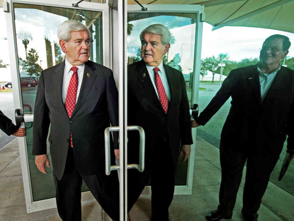 Newt Gingrich is refuting new attacks about his role at mortgage giant Freddie Mac. Gingrich's reflection is seen here as he walks out mirrored doors in Tampa, Fla. to deliver remarks and greet supporters on Jan. 23.