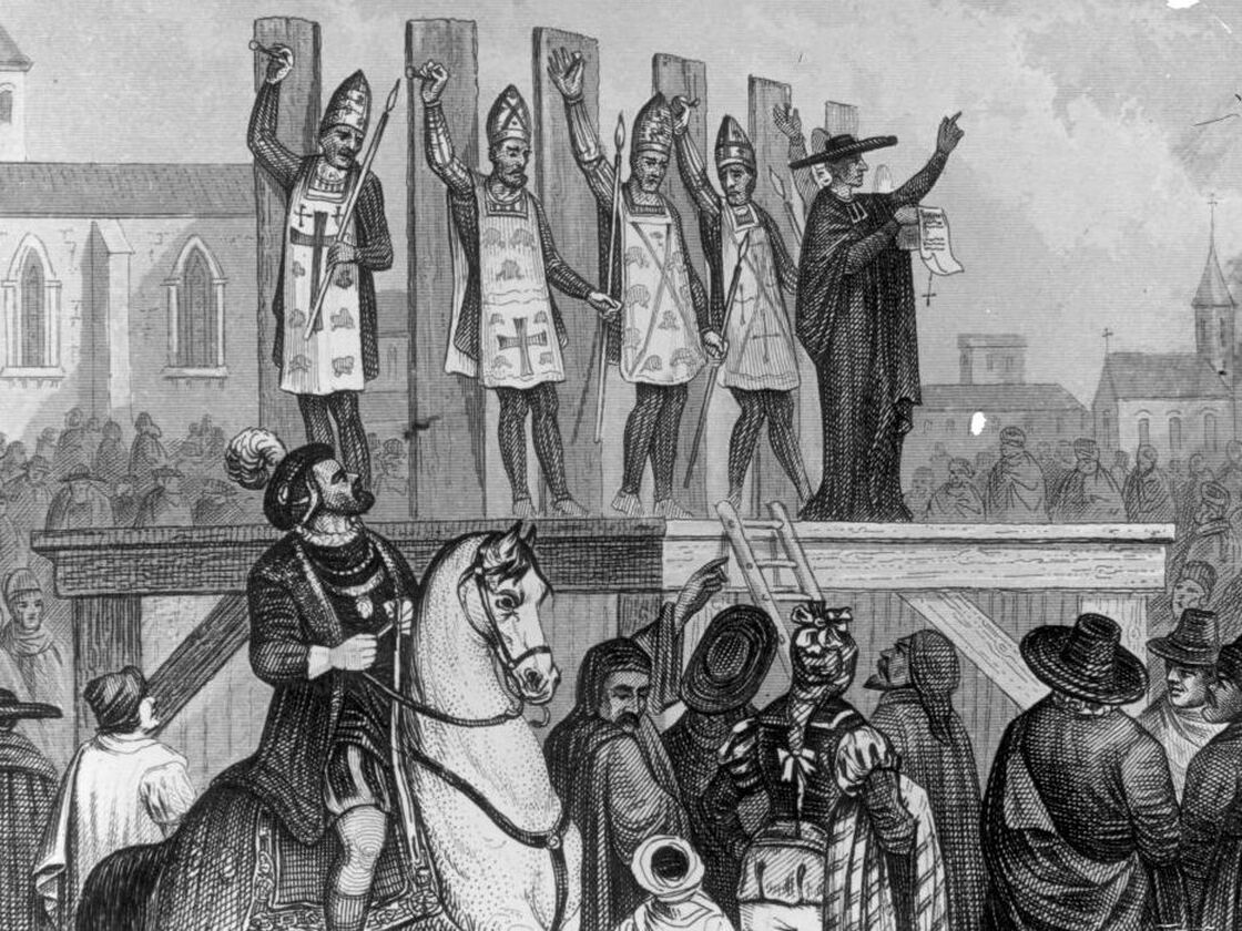 An illustration shows heretics being tortured and nailed to wooden posts during the first Inquisition.
