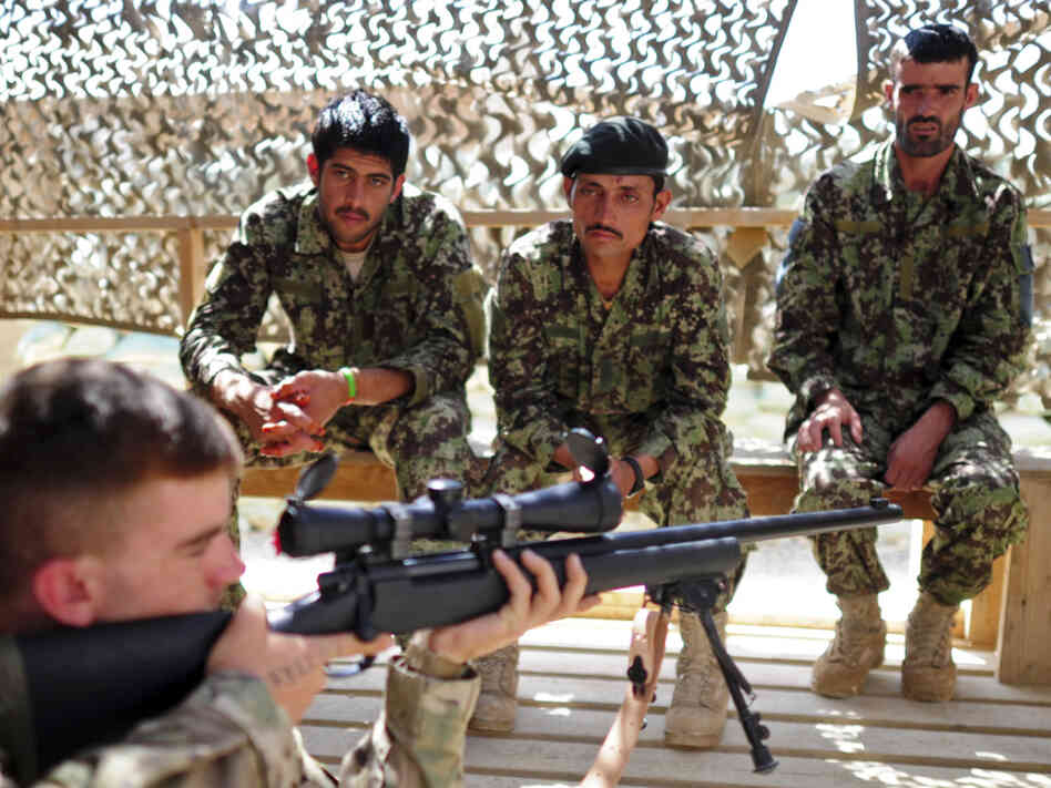 A U.S. soldier with a sniper rifle provides instruction to Afghan troops in the eastern province of Paktika last September.