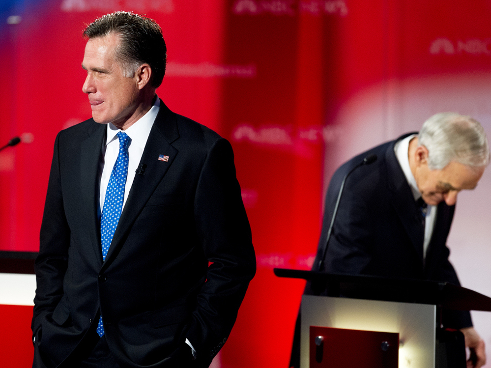 Mitt Romney stands on the stage during a commercial break as Republican presidential hopefuls take the stage for the  Debate at the University of South Florida, Jan. 23, 2012, Tampa, Florida. Romney has suffered under attacks about his time at Bain Capital.