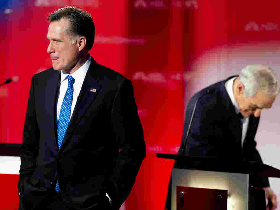 Mitt Romney stands on the stage during a commercial break as Republican presidential hopefuls take the stage for the  Debate at the University of South Florida, Jan. 23, 2012, Tampa, Florida. Romney has suffered under attacks about his time at Bain Capital.