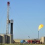 Natural gas is burned off next to an oil well being drilled at a site  near Tioga, N.D., in August. U.S. oil production started increasing a few years ago and is predicted to continue to rise, reducing the country's dependence on oil imports. 