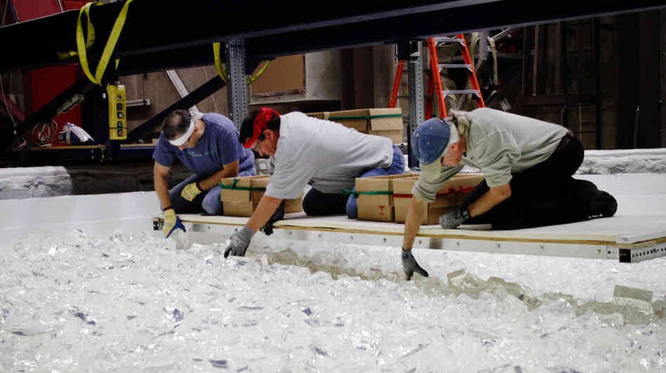 The pieces of glass that technicians are arranging inside the rotating oven will melt down into the curved surface of the telescope mirror. Each piece of glass is hand-inspected.