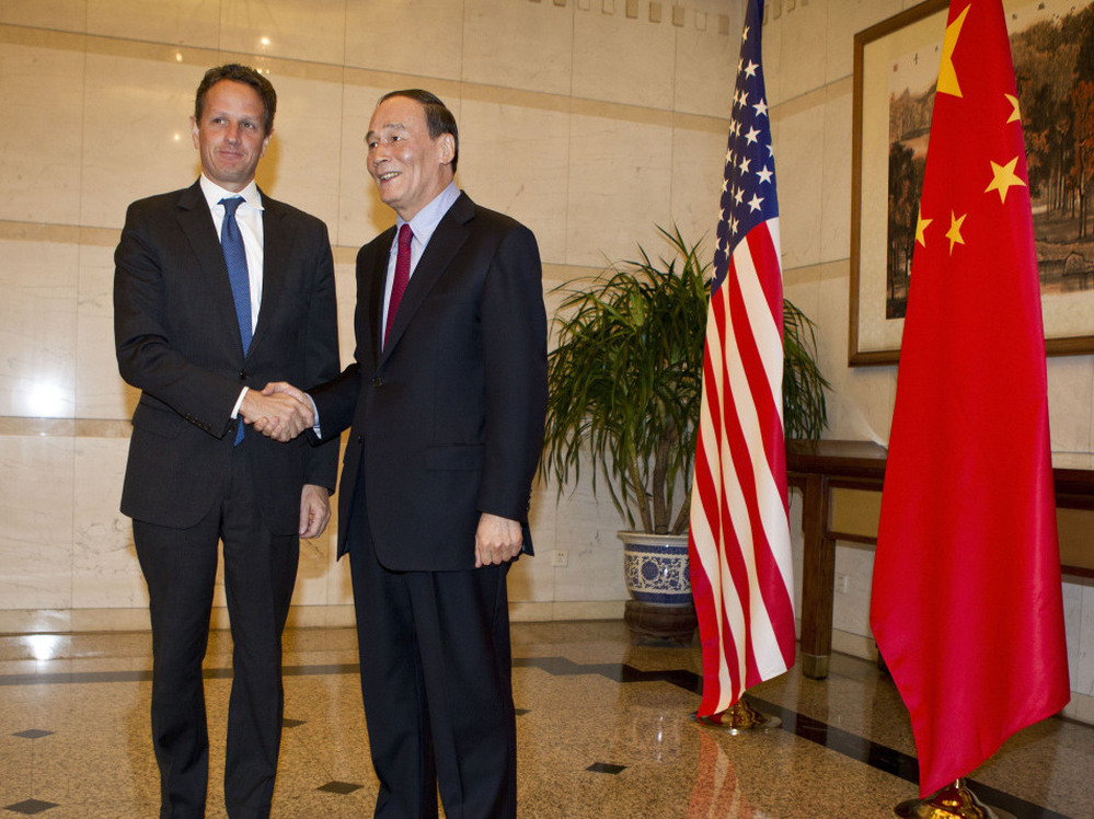 BEIJING, CHINA - US Treasury Secretary Timothy Geithner (L) shakes hands with Chinese Vice Premier, Wang Qishan before attending a dinner at the Diaoyutai State Guesthouse on January 10, 2012 in Beijing, China.