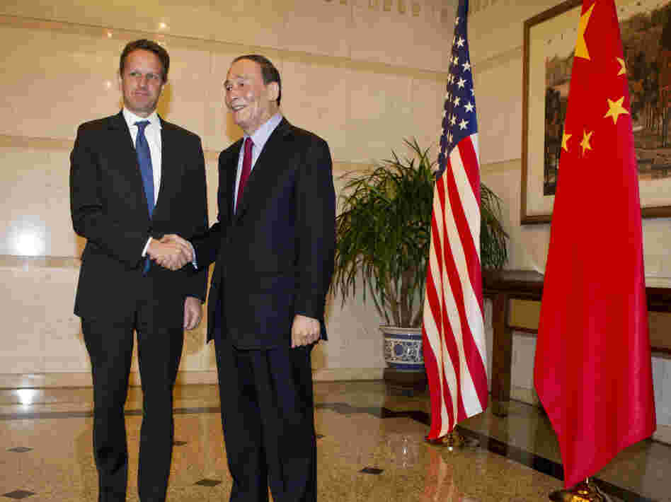 BEIJING, CHINA - US Treasury Secretary Timothy Geithner (L) shakes hands with Chinese Vice Premier, Wang Qishan before attending a dinner at the Diaoyutai State Guesthouse on January 10, 2012 in Beijing, China.