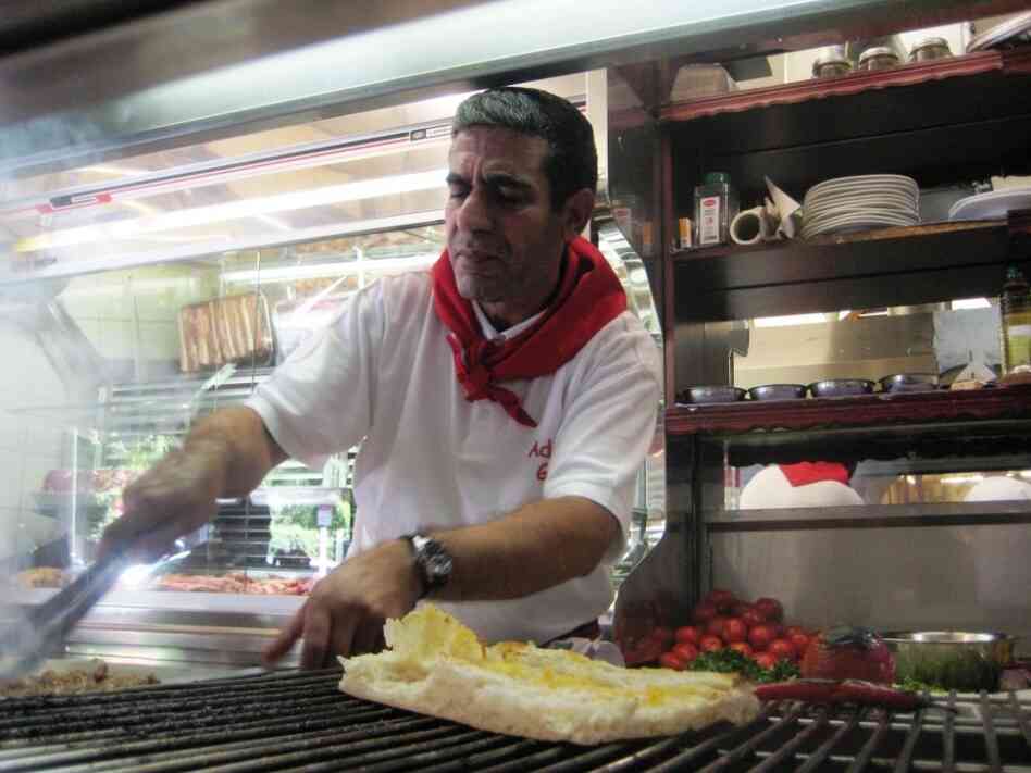 A cook at Adana Grill Haus grills adana kebab and kuzu pirzola. Cevat Akpolat, the owner of Adana Grill Haus in Kreuzberg, says his restaurant is more than just Turkish snacks. "This is a Turkish culture restaurant."