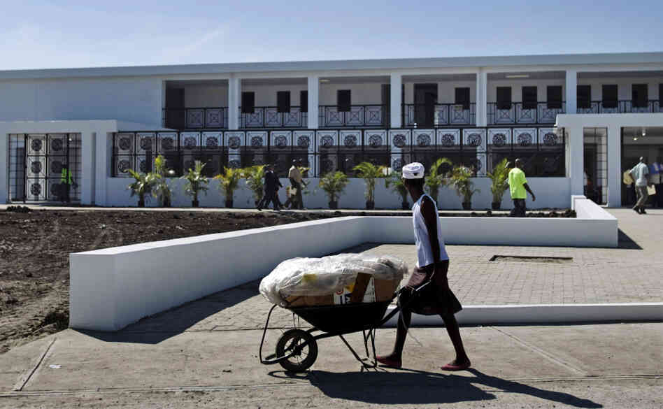 A worker pushes a wheelbarrow past the new National Teaching Hospital in Mirebalais, Haiti, on Jan. 10. When it opens this summer, the 320-bed facility will be Haiti's largest hospital and provide services and a level of care well beyond what's currently available.