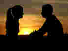 A couple with a sunset in the background. A couple with a sunset in the background.