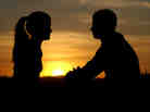 A couple with a sunset in the background.