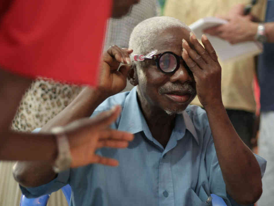 A man from Liberia uses a pump to adjust his liquid silicon lens. Liquid-lens glasses are part of an effort to make eyewear more accessible in the developing world.