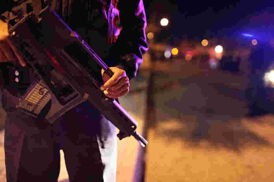 Police stand near the scene of a murder in Juarez, Mexico. The country suffers from drug cartel-related violence despite some of the most restrictive gun laws in the world. Police stand near the scene of a murder in Juarez, Mexico. The country suffers from drug cartel-related violence despite some of the most restrictive gun laws in the world.