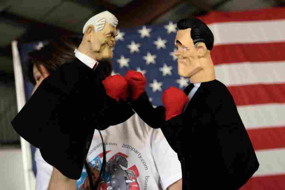 Lynn Coffin holds boxing hand puppets of former House Speaker Newt Gingrich (left) and former Massachusetts Gov. Mitt Romney during a campaign event this week in Sarasota, Fla. Lynn Coffin holds boxing hand puppets of former House Speaker Newt Gingrich (left) and former Massachusetts Gov. Mitt Romney during a campaign event this week in Sarasota, Fla.