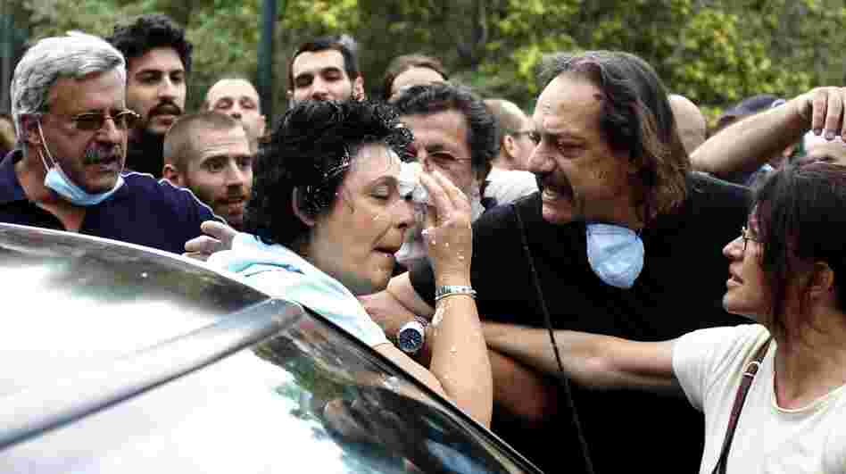 Communist party lawmaker Liana Kanelli enters her car after protesters threw yogurt on her face as she tried to reach the Greek parliament during a 48-hour general strike in Athens in 2011.