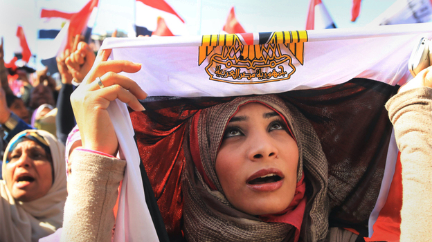 The U.S. is insisting that Egypt establish a full-fledged democracy and move away from military rule. Here, an Egyptian woman covers her head in a national flag as she demonstrates in a pro-democracy rally in Cairo's Tahrir Square on Jan. 27.
