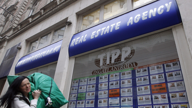 A woman passes by a real estate agency in Budapest, Hungary, in January. As the Hungarian currency plunges to new lows, ordinary citizens are struggling to repay foreign-denominated loans. A woman passes by a real estate agency in Budapest, Hungary, in January. As the Hungarian currency plunges to new lows, ordinary citizens are struggling to repay foreign-denominated loans.