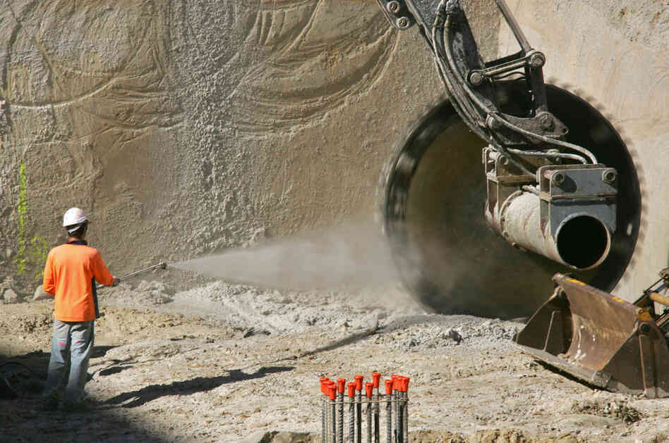 A worker sprays water onto a large circular saw as the machine cuts sandstone in Sydney, Australia, in 2005. Applying water can help reduce the amount of dust that makes it into the air.