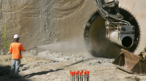 A worker sprays water onto a large circular saw as the machine cuts sandstone in Sydney, Australia, in 2005. Applying water can help reduce the amount of dust that makes it into the air.