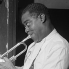 Louis Armstrong entertains a young fan backstage. Louis Armstrong entertains a young fan backstage.