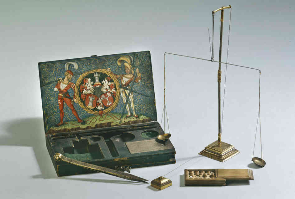 Beautifully decorated tools were constructed to balance and weigh gold and gemstones. This set has a wooden case covered with painted paper, iron and partially gilded silver.
