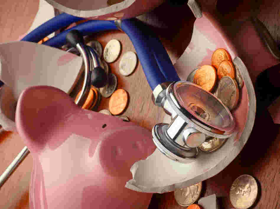 A stethoscope rests on a broken piggy bank. A stethoscope rests on a broken piggy bank.