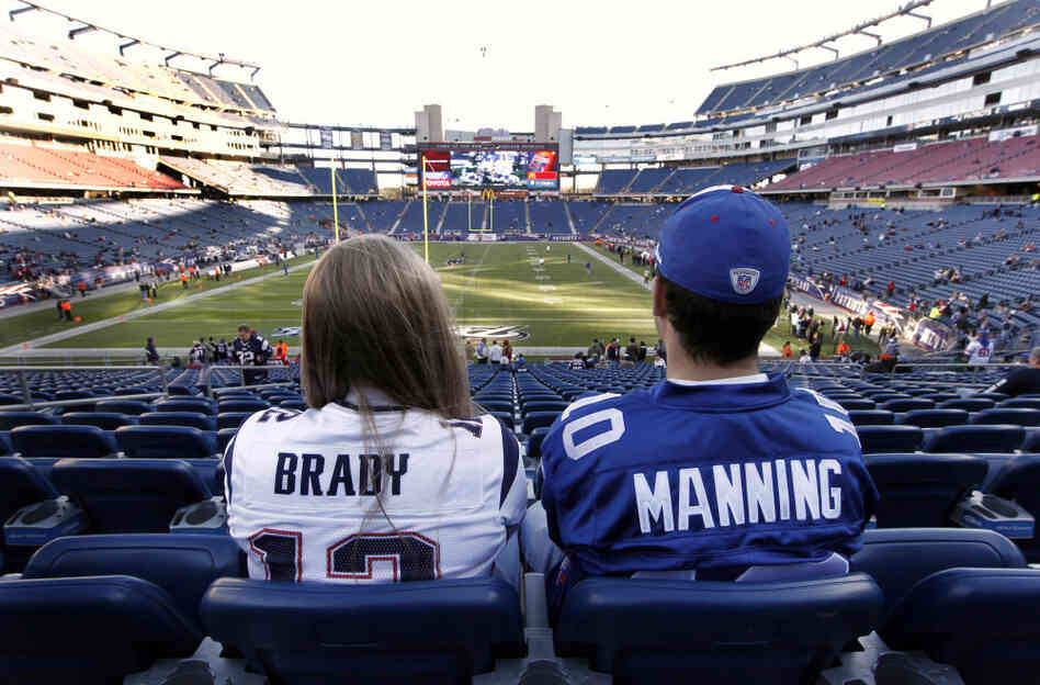 Fans in Tom Brady and Eli Manning jerseys sit before a November game between the New England Patriots and the New York Giants in Foxborough, Mass. Heading into a Super Bowl rematch, neighboring Connecticut's fans are split between the teams. Fans in Tom Brady and Eli Manning jerseys sit before a November game between the New England Patriots and the New York Giants in Foxborough, Mass. Heading into a Super Bowl rematch, neighboring Connecticut's fans are split between the teams.