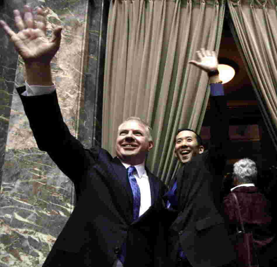 Sen. Ed Murray, D,, left, and his partner Michael Shiosaka wave at spectators in the upper gallery after the Washington state Senate voted for a proposal to legalize same-sex marriage.