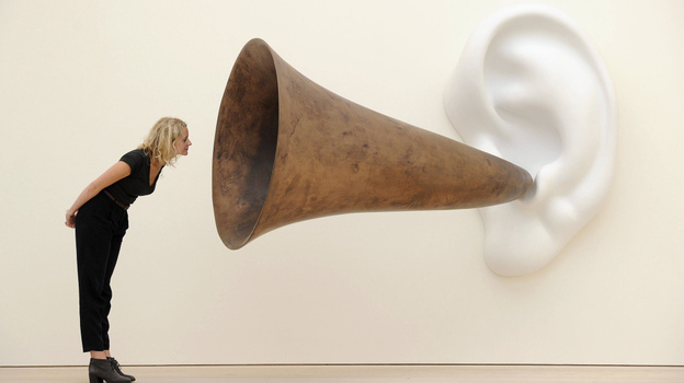 An employee poses next to an installation by US artist John Baldessari entitled 'Beethoven's Trumpet (With Ear)' at the Saatchi Gallery in central London on May 26, 2011.