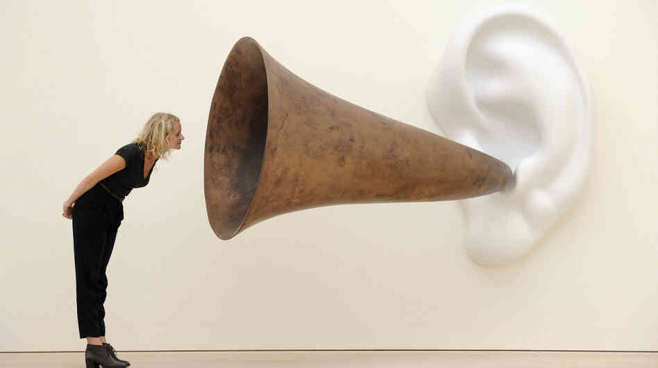 An employee poses next to an installation by US artist John Baldessari entitled 'Beethoven's Trumpet (With Ear)' at the Saatchi Gallery in central London on May 26, 2011.